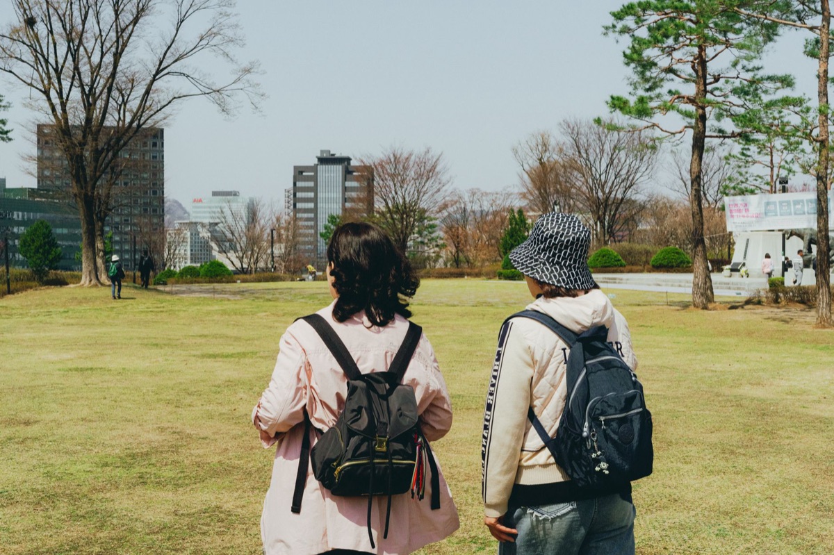 Nederlandse lezer begrijpt de betekenis van een reiziger met backpack en de visuele context van een reis naar Korea.