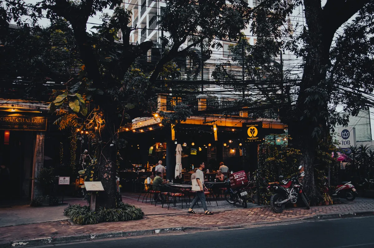 Charming outdoor dining area of a restaurant at twilight with a bustling city vibe.