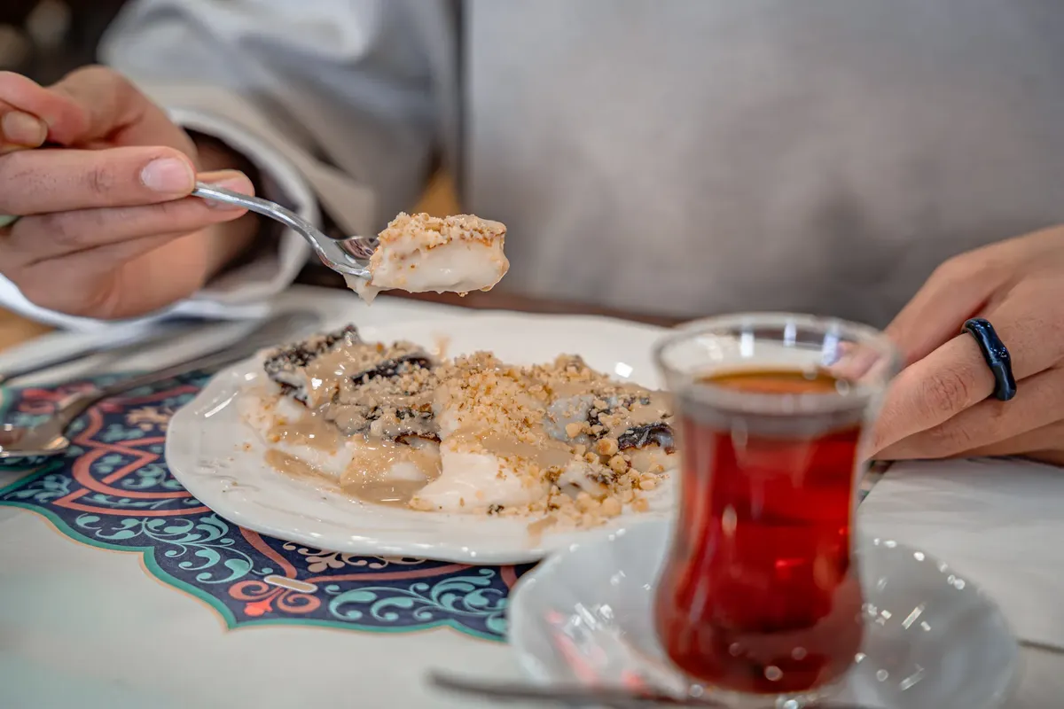 Savoring a traditional Turkish dessert served with tea at a local café in Bursa, Türkiye.