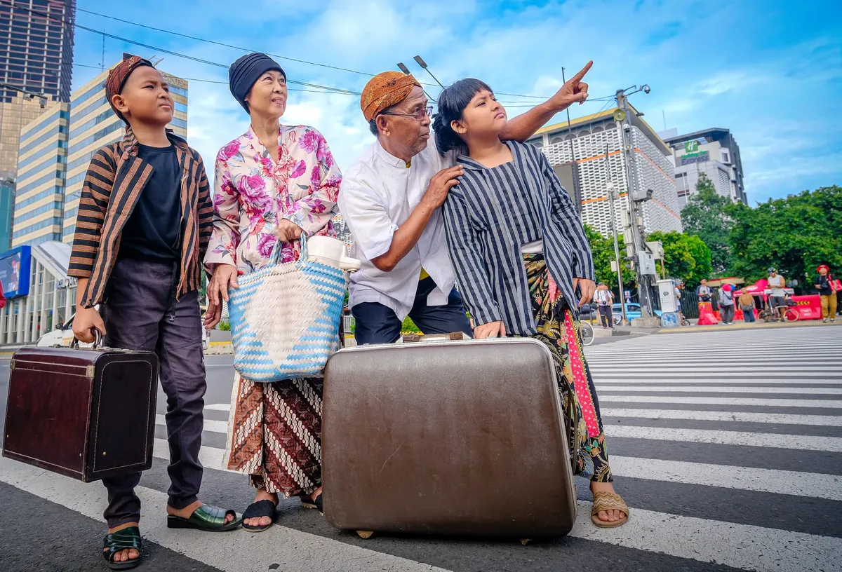 A family in traditional Javanese clothing crosses a street in Jakarta, suggesting a cultural journey.